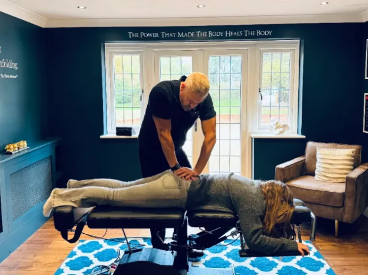 Dr Stephen Davison performing a gentle chiropractic adjustment on a patient lying on the treatment bench